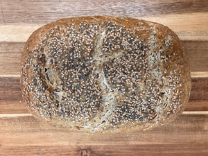 Loaf of bread with sesame seeds on a wooden surface