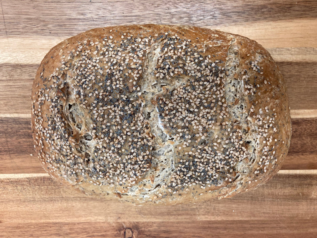 Loaf of bread with sesame seeds on a wooden surface